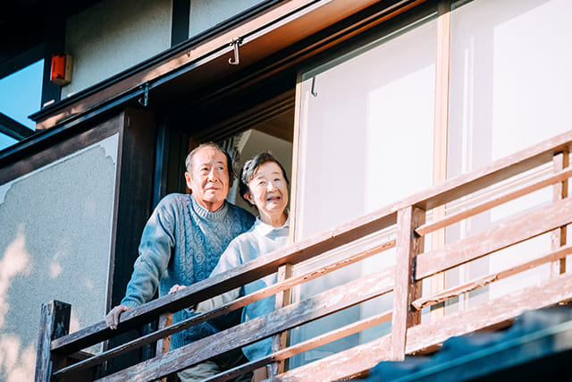 窓に佇むシニア世代の夫婦