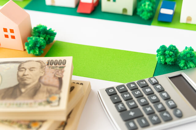 住宅の模型、お金、電卓