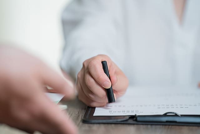 契約書に印鑑を押す手元