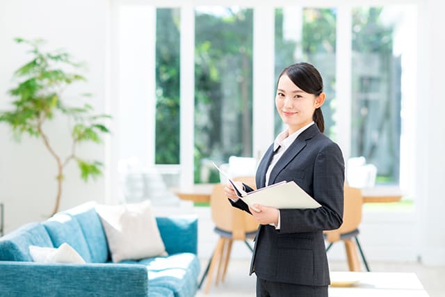 家の中に立つスーツを着た女性
