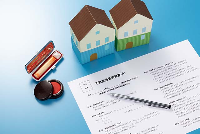 家の模型と不動産売買契約書