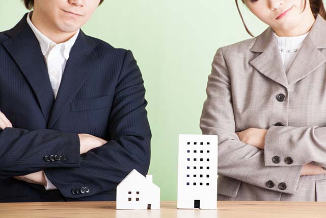 マンションと戸建ての模型を見て悩むカップル