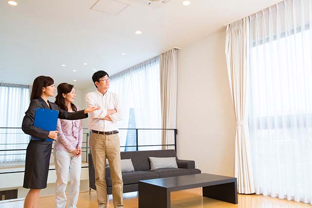 新居を検討する夫婦と不動産会社のスタッフ