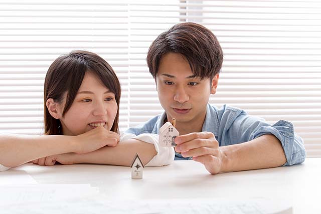 家の模型を見る若い夫婦