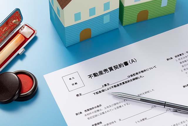 家の模型と契約書