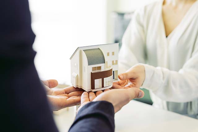 家の模型を受け渡す様子