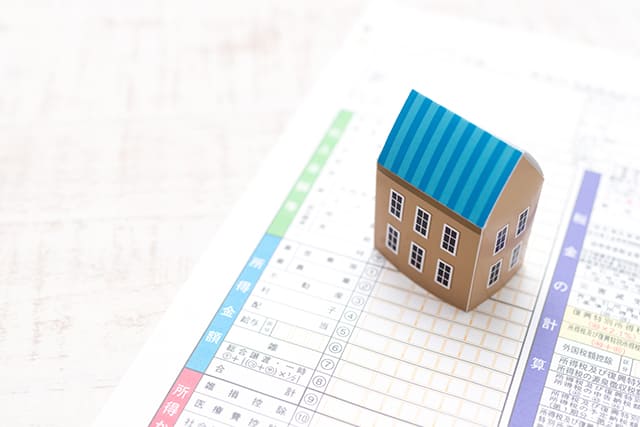 家の模型と確定申告の用紙