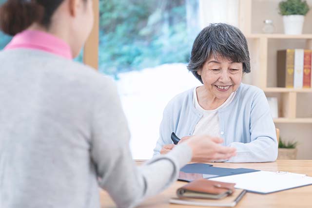 高齢女性に説明をするスタッフ