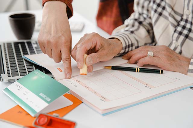 シニア男性の手元、印鑑、書類