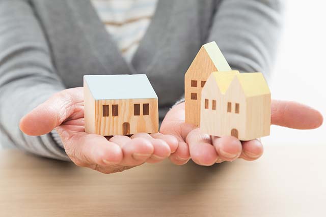 家の模型をもつ手