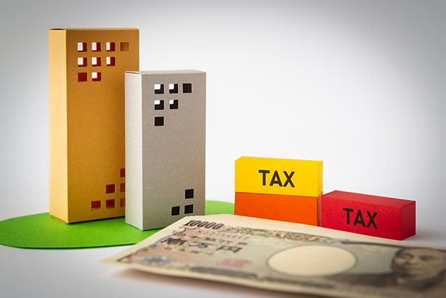 マンションや税金の模型と現金