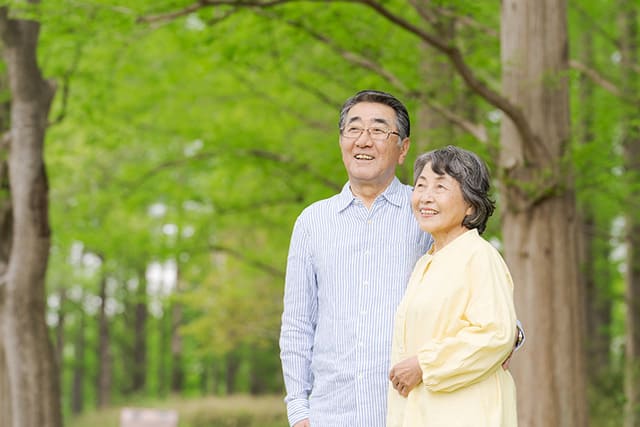 公園を散歩するシニア世代の夫婦