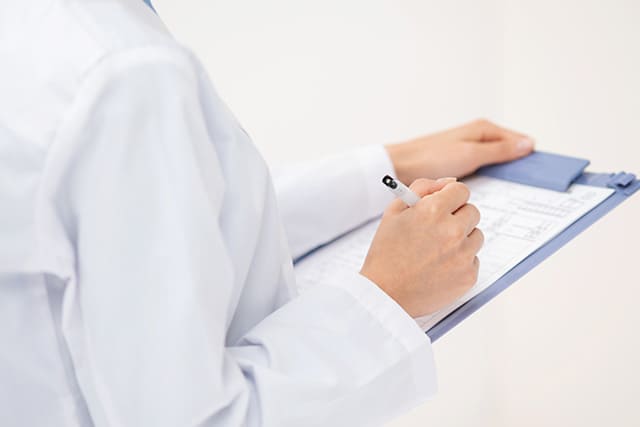 カルテを記入する医師