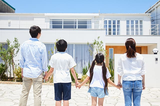 マイホームの前に立つ家族