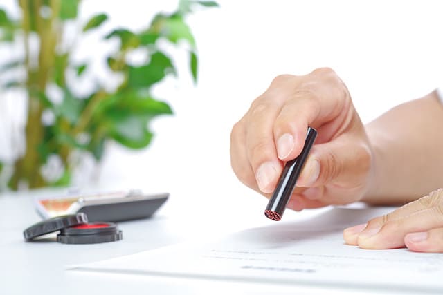 書類に印鑑を押す手