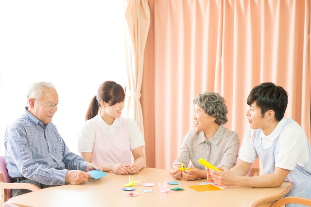 ケアハウスで団らんするシニアと介護士