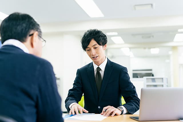 中年男性とスーツを着た職員