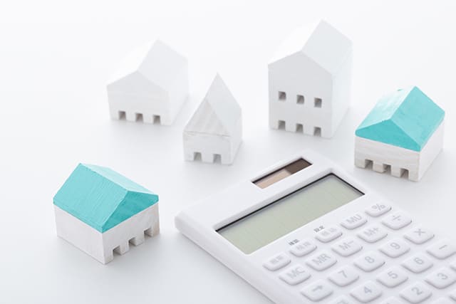 白い電卓と家の模型