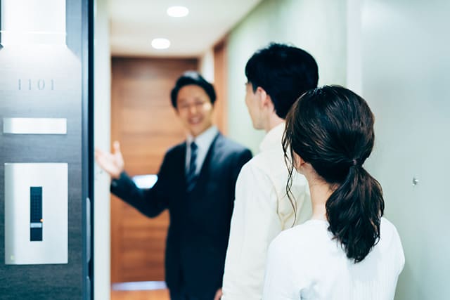 物件を案内する男性と案内される男女