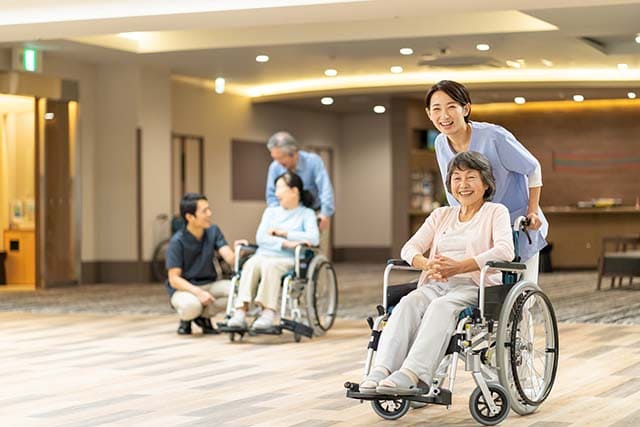 車椅子の高齢者と介護士