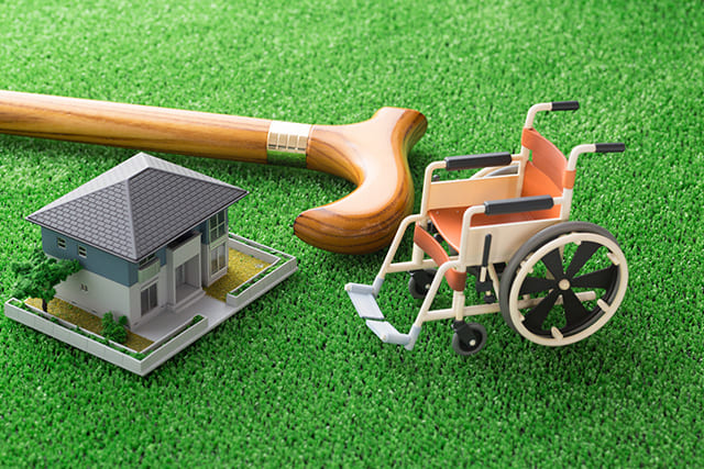 家と車椅子の模型と杖