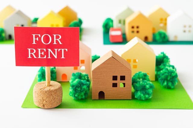 FOR RENTとかかれた看板と家の模型