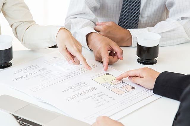 間取り図を見る人たち