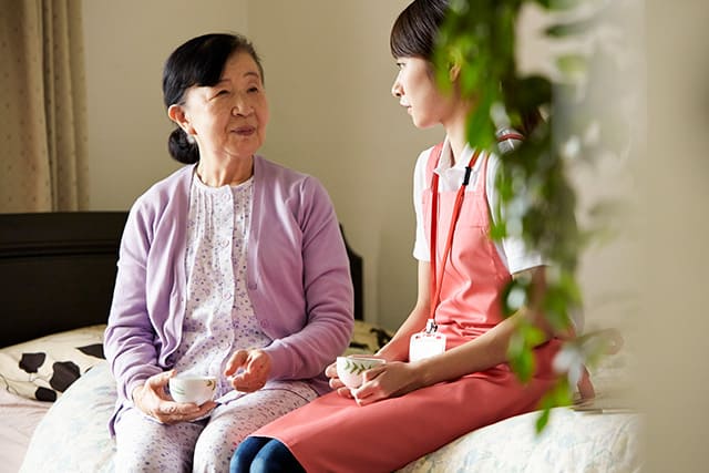 一人暮らしの高齢者と訪問看護のスタッフ