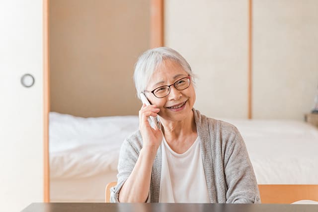 携帯電話で話す高齢者の女性