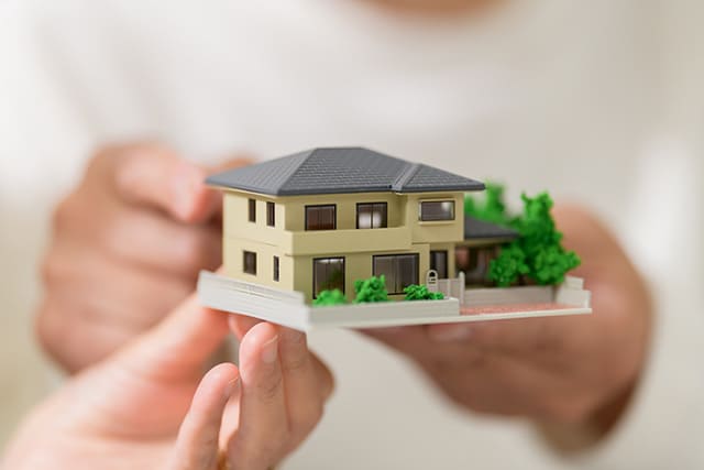 家の模型を持つ人