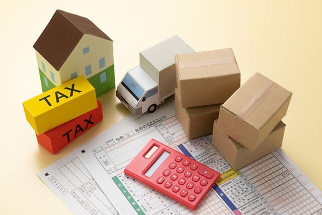 家、トラック、段ボールの模型と電卓