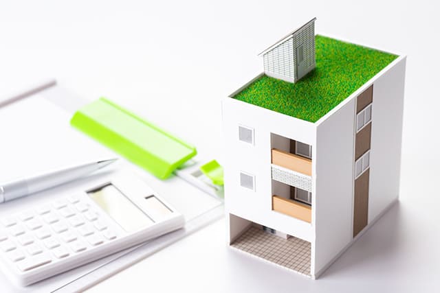電卓と白い家の模型