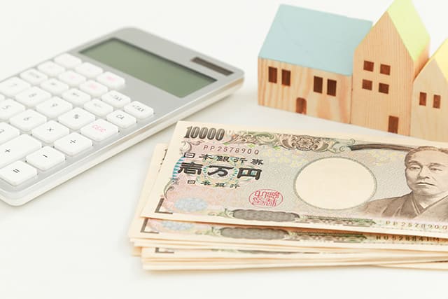 紙幣と電卓と家の模型