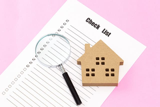 チェックリストと虫眼鏡と家の模型