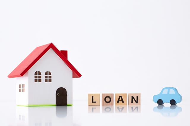 家の模型と「LOAN」の英字ブロックと車の模型