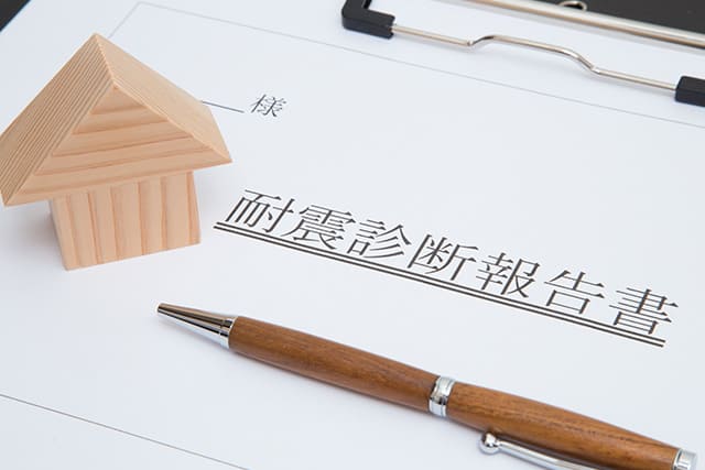 耐震診断報告書の書類と家の模型とペン