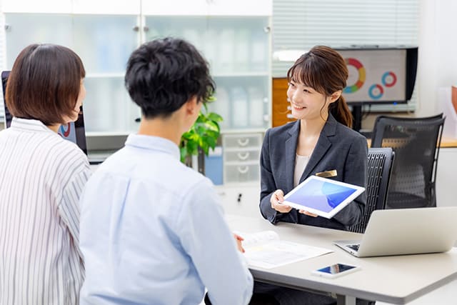 不動産会社の営業担当者と話す男女