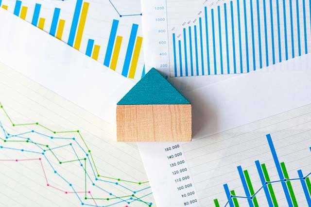家の模型と不動産価格の推移を示すグラフ