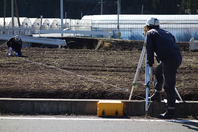 土地の測量する2人の男性