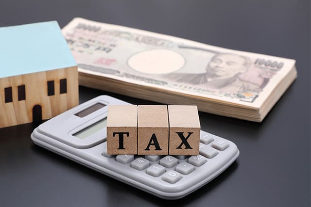 １万円札と電卓と住宅とTAX