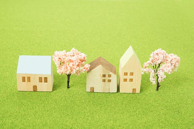 木製の住宅模型と桜の木