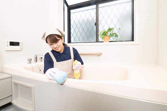 浴室の掃除をするハウスクリーニングの女性スタッフ