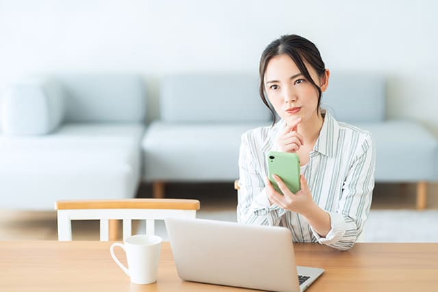 スマホで簡易査定中の女性