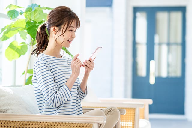 スマホで匿名査定を申し込む若い女性