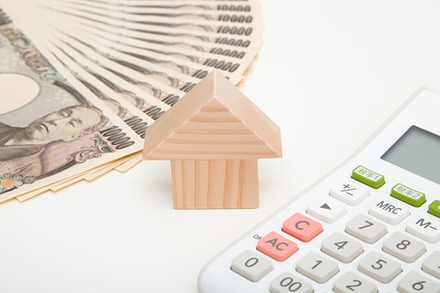 住宅の模型とお金と電卓