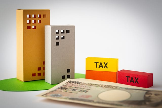 不動産と税金の模型と紙幣