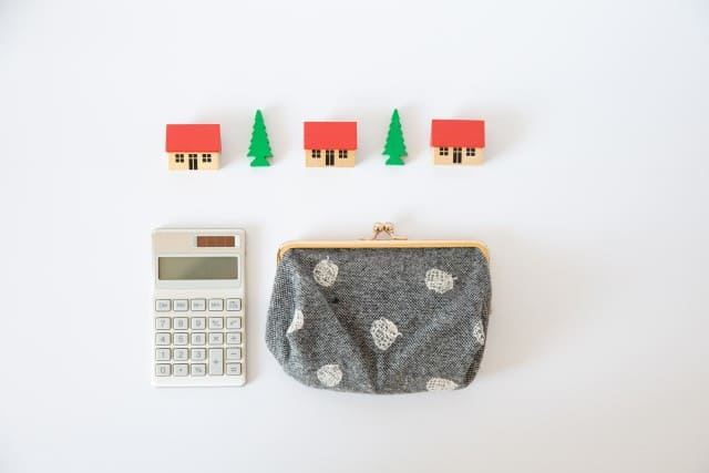 電卓と財布と家の模型