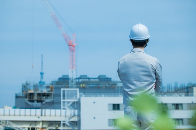 マンションの建築現場を眺める男性