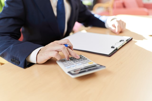 取得費の計算をしている不動産営業担当者