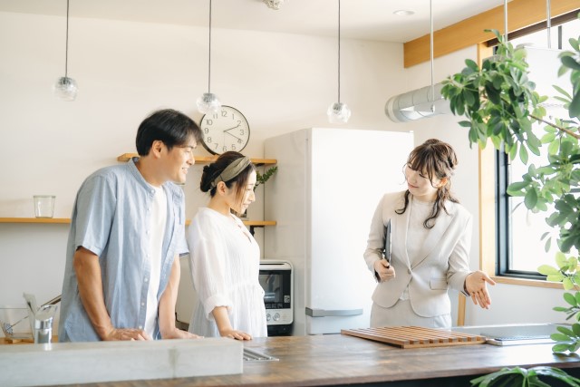 内見でキッチンを見る夫婦
